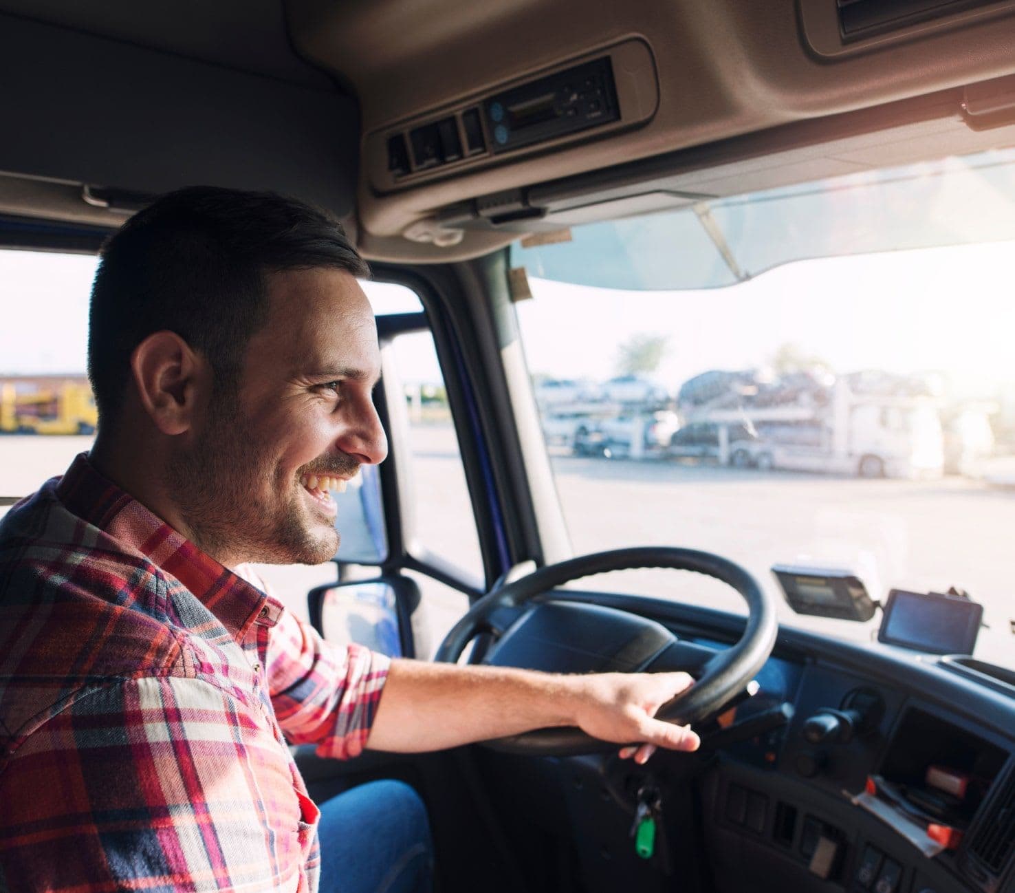 Truck driver leaving a parking lot in his vehicle, on his way to his next freight.